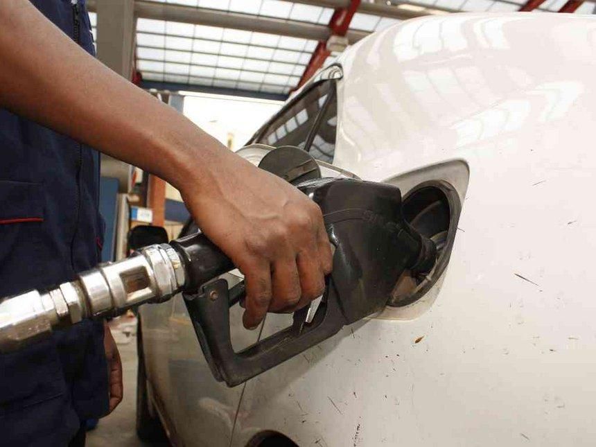 A petrol station attendant fuelling a car