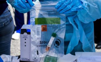 A health worker stores coronavirus test samples at a drive-through clinic in West Palm Beach, Florida