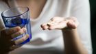 person-holding-antidepressant-and-a-glass-of-water