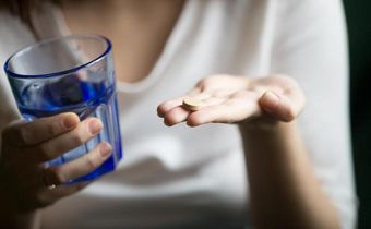 person-holding-antidepressant-and-a-glass-of-water