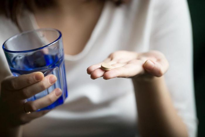 person-holding-antidepressant-and-a-glass-of-water