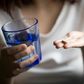 person-holding-antidepressant-and-a-glass-of-water