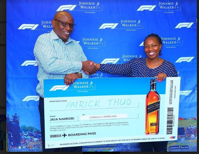 Patrick Thuo a Grand Prix winner from Nairobi receives his dummy air ticket from Hildah Njeri, Shoppers Manager International Premium Spirits. Mr Thuo is one lucky winners travelling to Azerbaijan Grand Prix through Experience Formula 1 with Johnnie Wa...