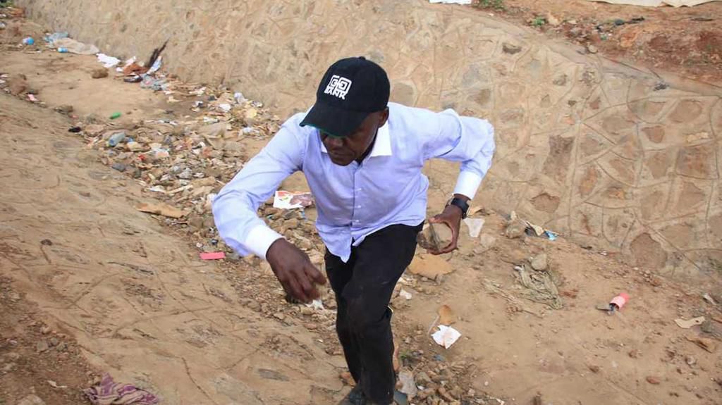 Former Kakamega Senator Bonny Khalwale carring stones