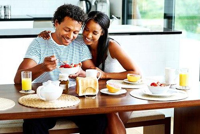 A happy young couple enjoying breakfast in their home.