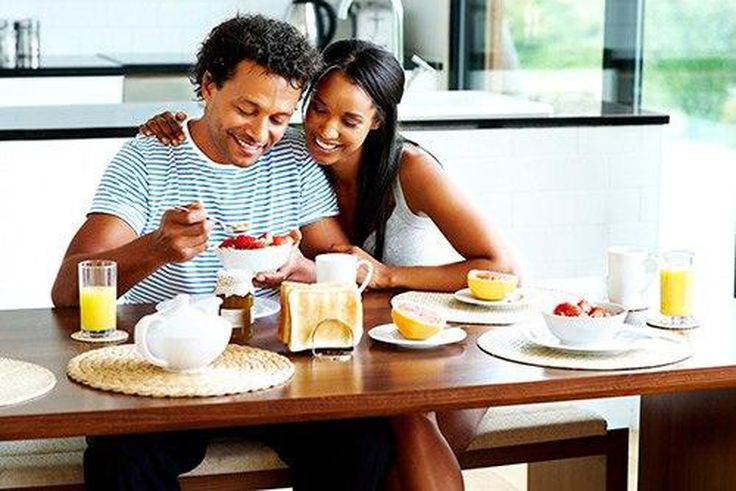 A happy young couple enjoying breakfast in their home.