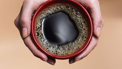 &quot;Woman holding coffee cup, close-up, overhead view&quot;