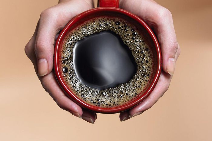 &quot;Woman holding coffee cup, close-up, overhead view&quot;