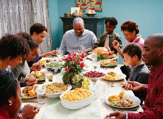 An African-American family praying before a Thanksgiving dinner