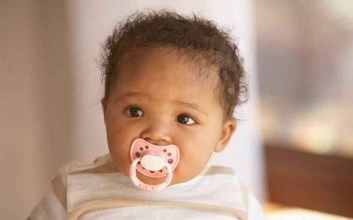Baby on pacifier (Ebony Magazine)
