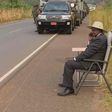 Ugandan president, Yoweri Museveni, making a phone call on the road side