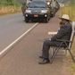 Ugandan president, Yoweri Museveni, making a phone call on the road side