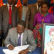 File image of Raila Odinga signing a condolence book He is among national leaders who has mourned Achieng Oneko's widow