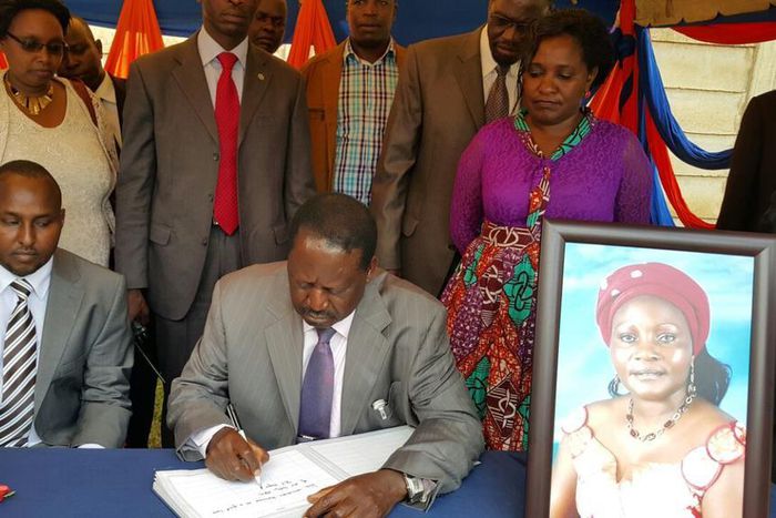 File image of Raila Odinga signing a condolence book He is among national leaders who has mourned Achieng Oneko's widow