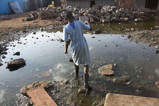 Schoolchild crossing over an open sewer