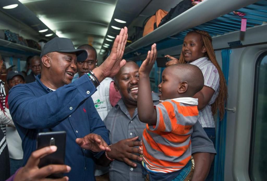 File image of President Uhuru Kenyatta interacts with commuters on the SGR train
