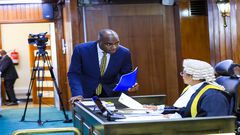 Speaker Among (R) is approached by State Minister, Musasizi as the House processed the loan request