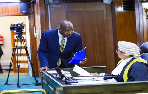 Speaker Among (R) is approached by State Minister, Musasizi as the House processed the loan request