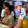A traveller getting his temperature checked  at the airport
