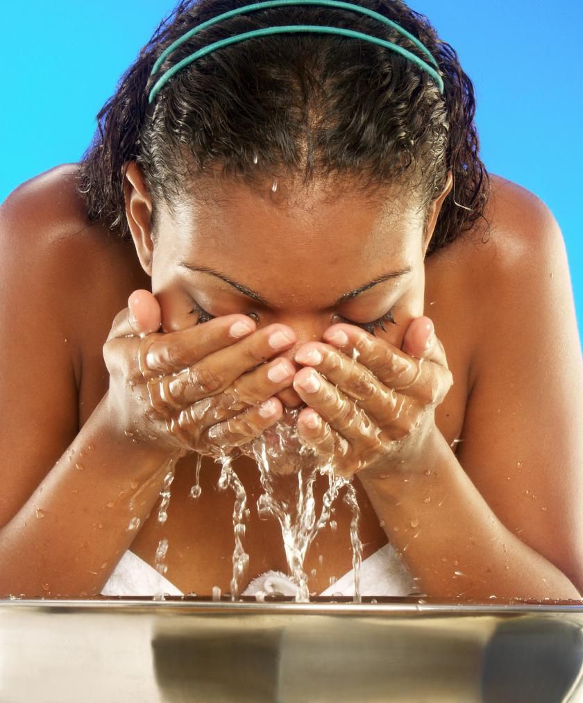 African woman washing her face