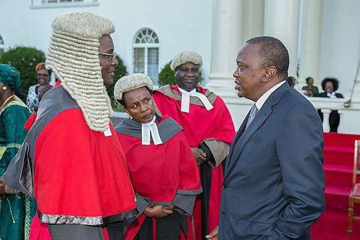 President Uhuru Kenyatta chats with Chief Justice David Maraga after the swearing-in of new judges of the High Court at State House, Nairobi.