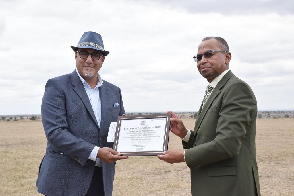 Tourism CS Najib Balala receives the Certificate of Registration from ILRI Director General Jimmy Smith after ILRI donated 32,000 acres of land to Nairobi National Park