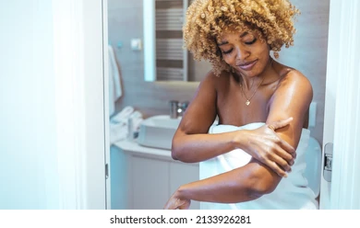 Applying body lotion when your body is wet [shuttershock]