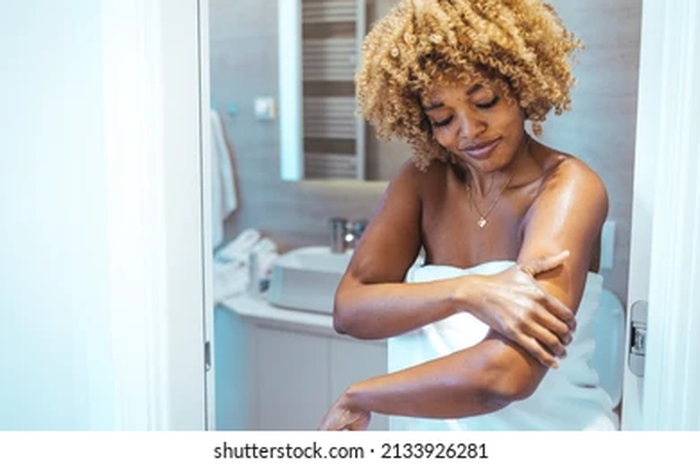 Applying body lotion when your body is wet [shuttershock]