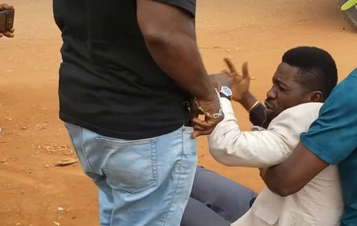Bobi Wine being helped up by his team