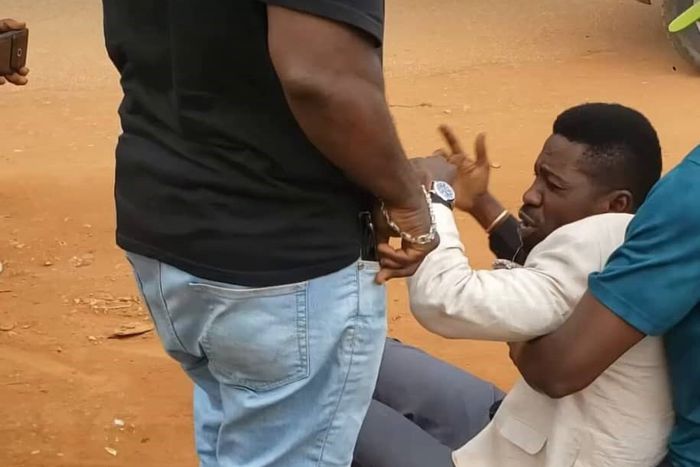 Bobi Wine being helped up by his team