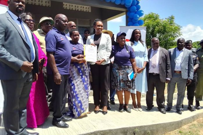 Minister Fiona Nyamutoro hands over a land title to one of the PAPs in Buliisa