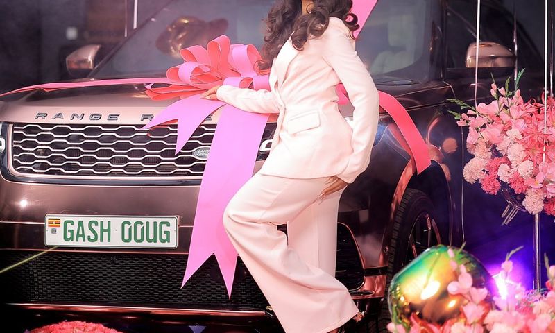 Sheilah Gashumba poses in front of her Range Rover