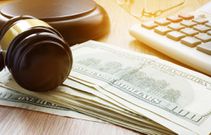 A stock image shows a gavel, keyboard, and dollar notes.designer491/Getty Images