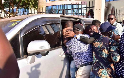 Akamba being bundled into a van by security