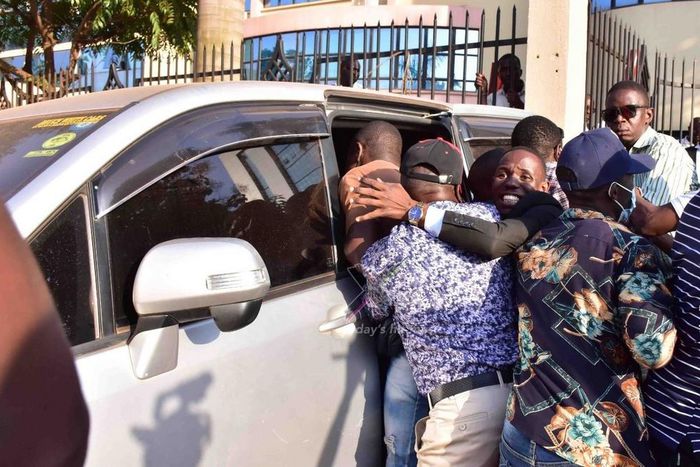 Akamba being bundled into a van by security