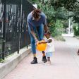 Mum and dad walking with their daughter outside [Image Credit: Greta Hoffman]
