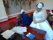 Aisha watches as Ajedra signs the marrriage papers