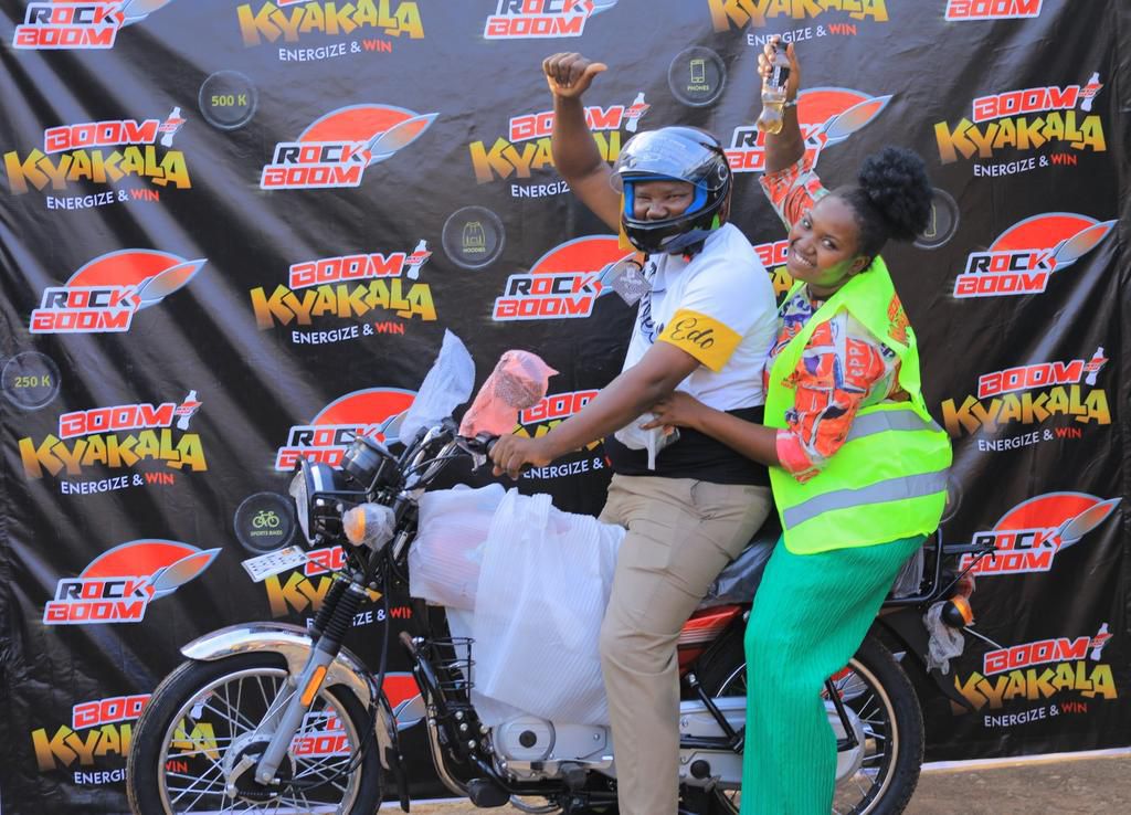 Lixa Iradukunda, who won a motorbike, celebrates with her father