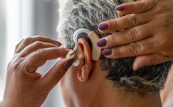 An elderly woman wearing hearing aid