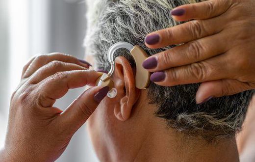 An elderly woman wearing hearing aid