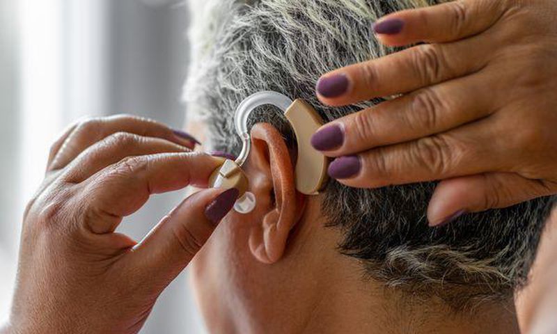 An elderly woman wearing hearing aid