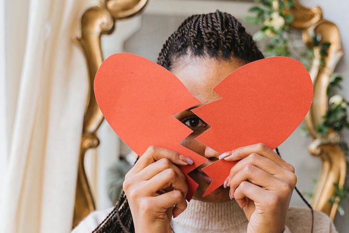 A woman holding a broken heart made of paper [Image: Antoni Shkraba]