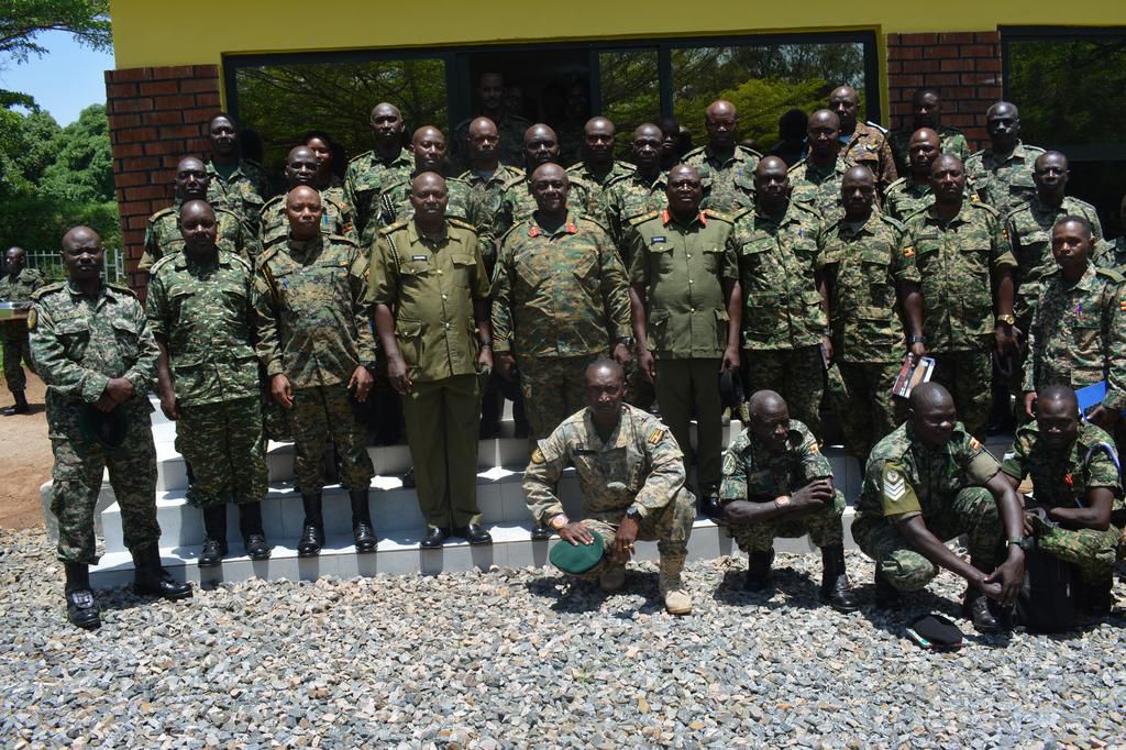 Brig Kabango pausing for a group photo with the outgoing Col Tom (R) and Lt Col Moses Kaggwa (L) with staff officers at 4Inf  Div Hqs