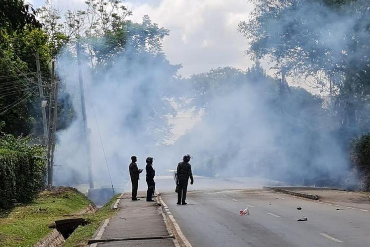 Police look on after launching tear gas