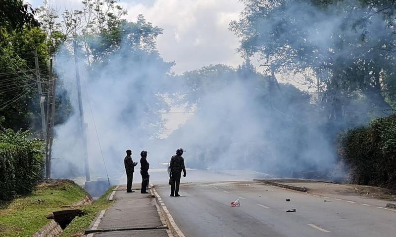 Police look on after launching tear gas