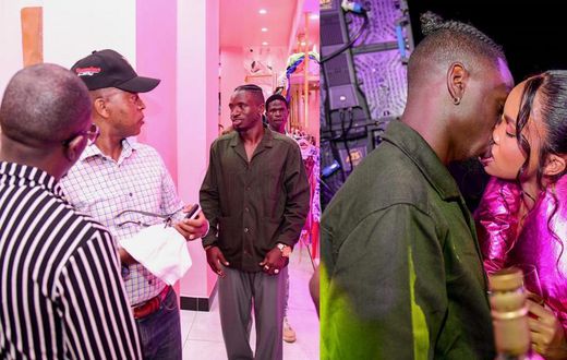 Rickman talking to Frank Gashumba. Rickman kissing Sheilah.