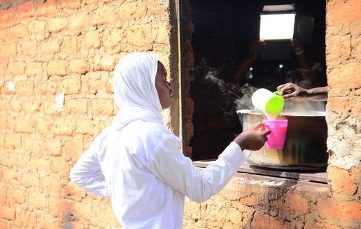 A student getting porridge from the Kitchen at Barakala Seed Secondary School