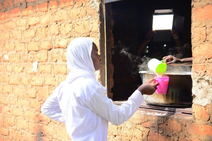 A student getting porridge from the Kitchen at Barakala Seed Secondary School