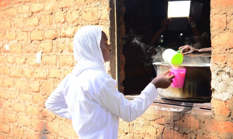A student getting porridge from the Kitchen at Barakala Seed Secondary School