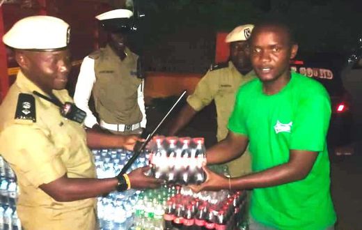 SSP Rogers Nsereko Kauma, the Kampala Metropolitan Traffic Police Commander recieving the refreshementfrom CCBU's Kirunda Magoola